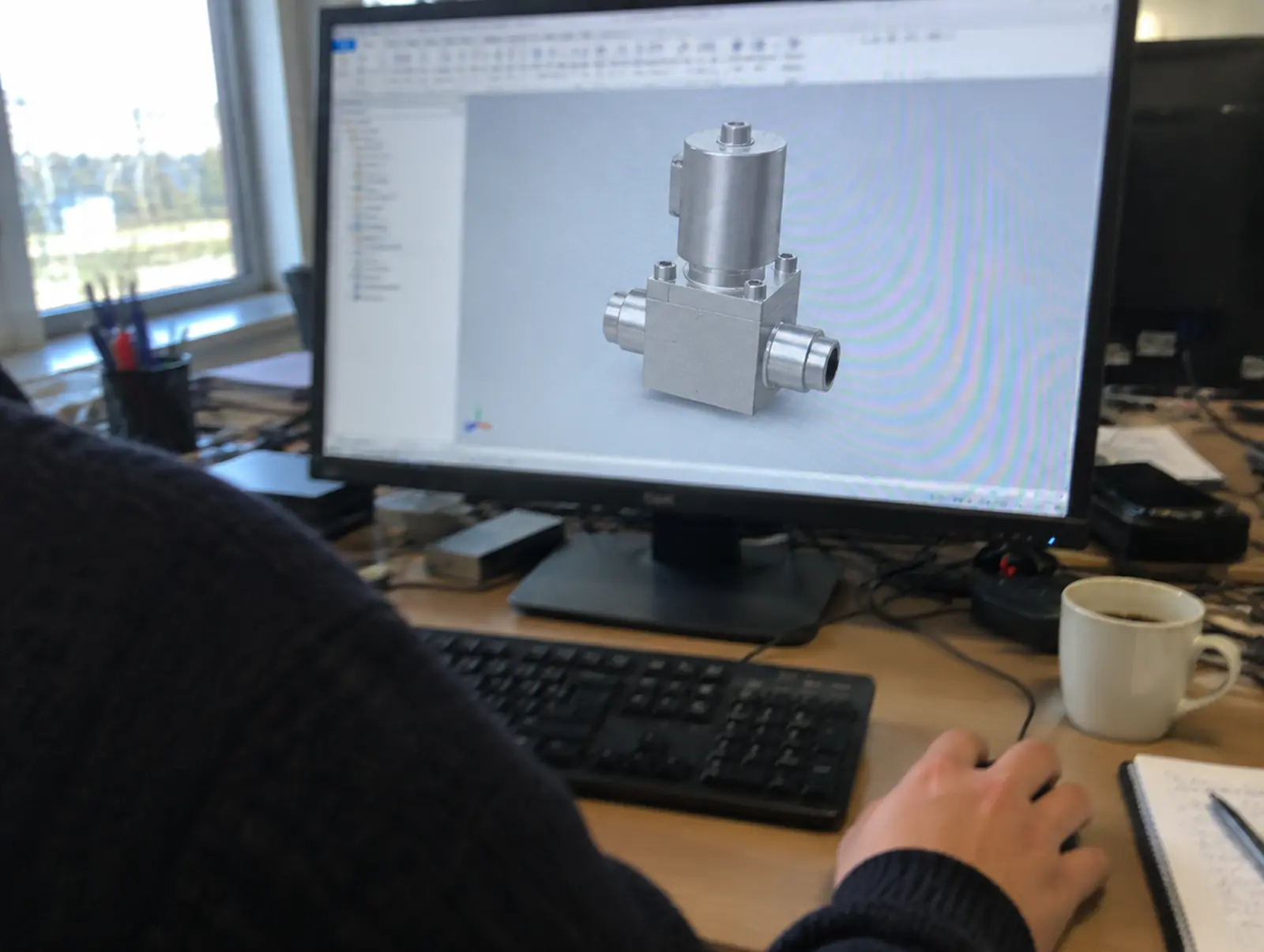 모니터에 띄운 반도체용 소형 밸브의 3D CAD 모델과 마우스 위의 손